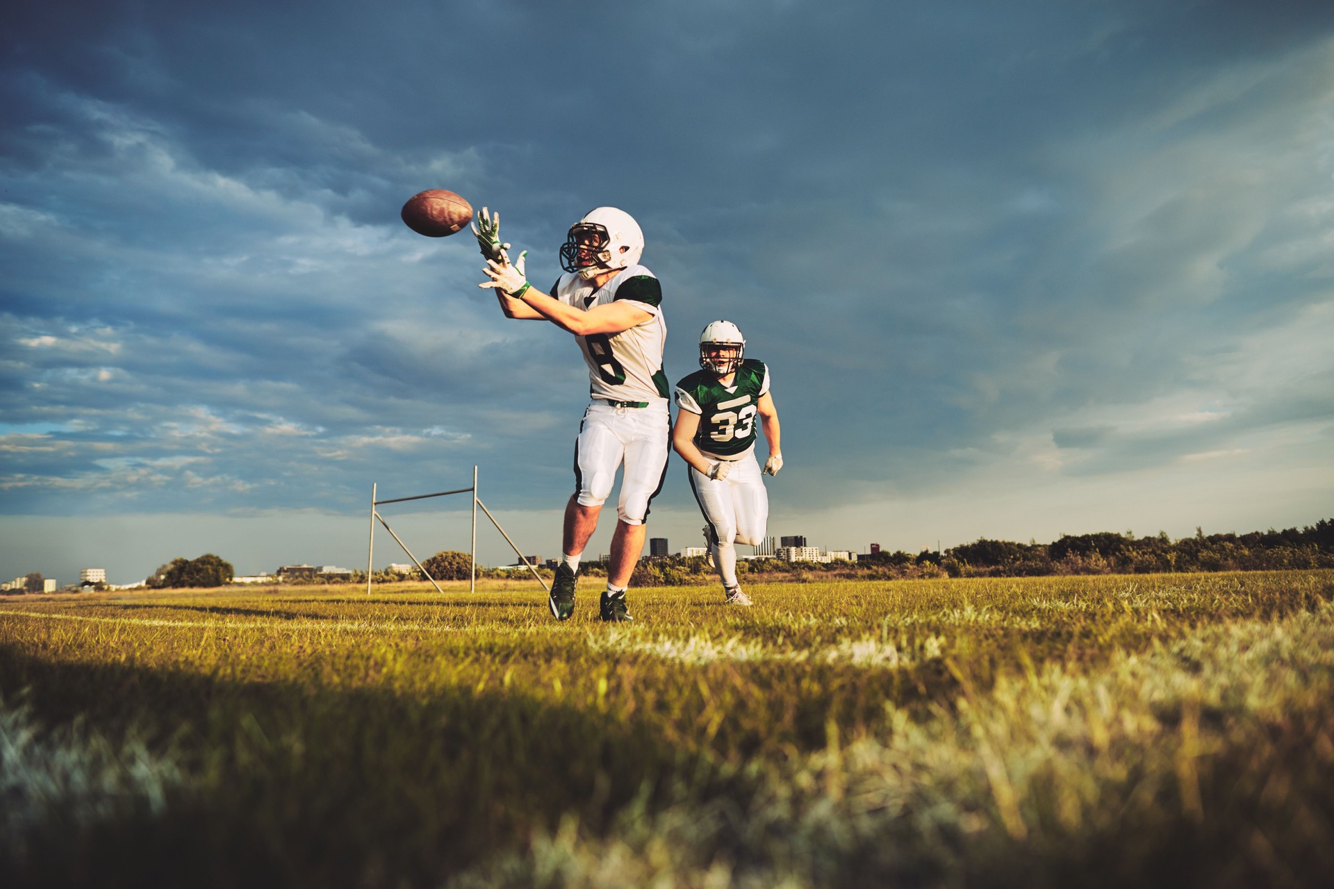 American football player catching a pass during team drills
